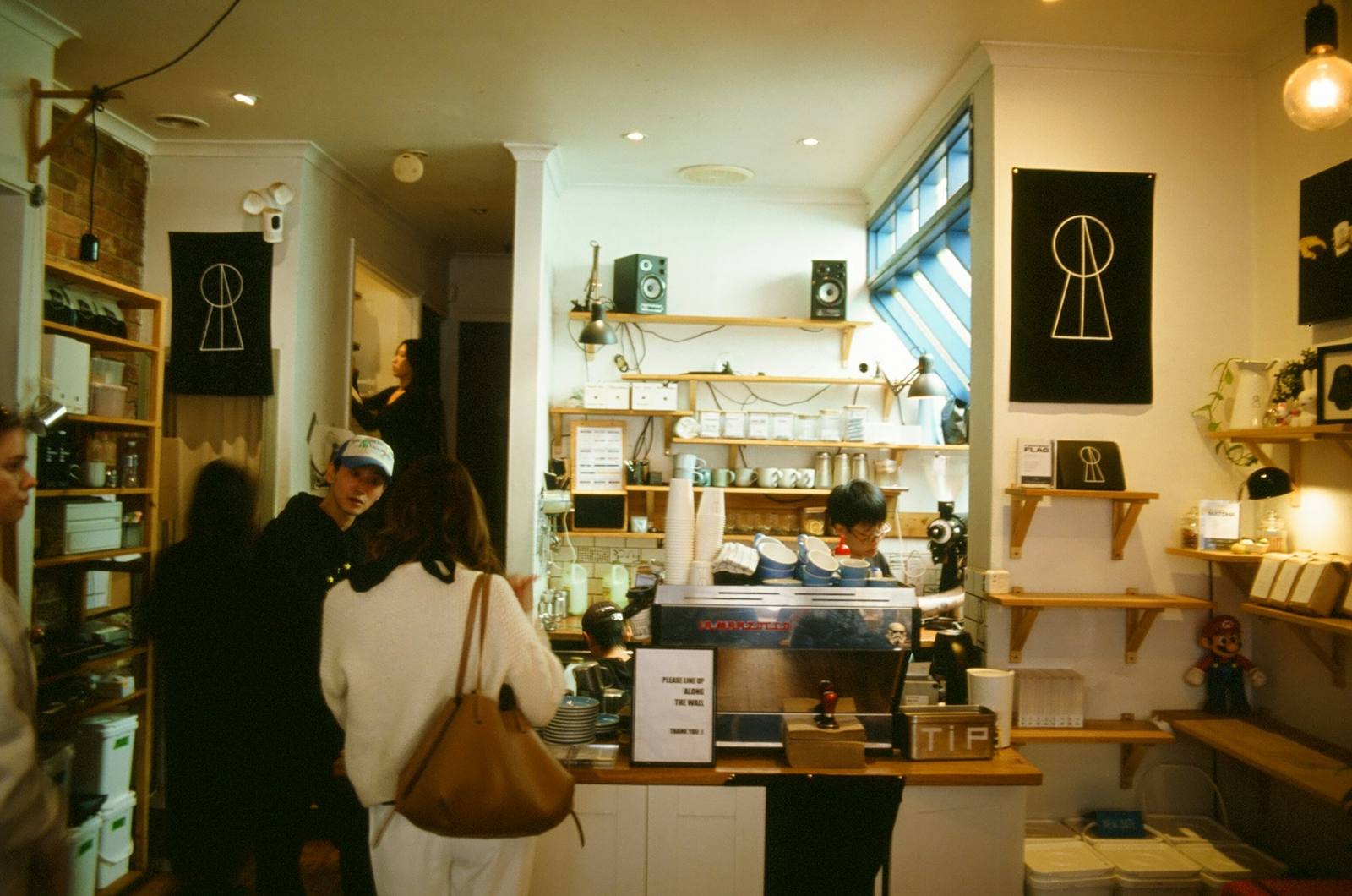 Customers order at the counter of a busy neighbourhood coffee shop